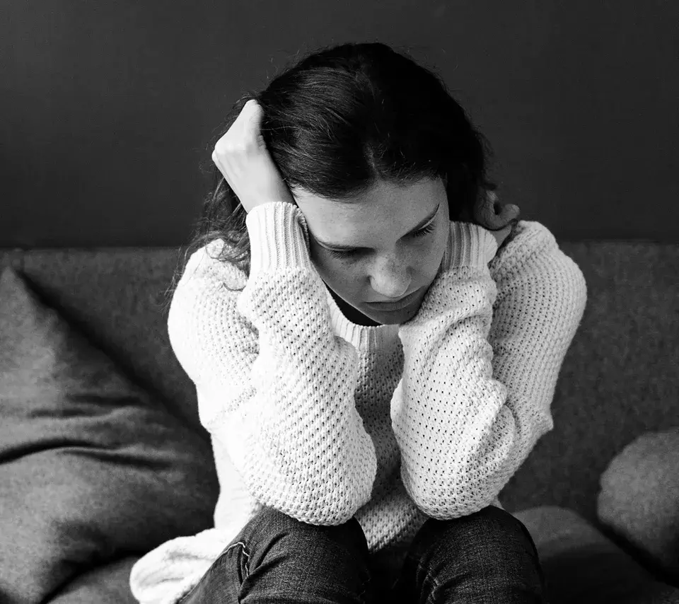 Photo d'une jeune fille pensive recroquevillée sur elle-même